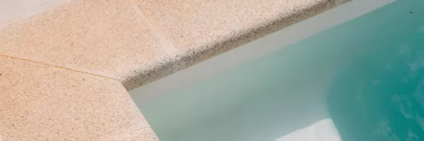 Close-up of paver coping capping the edge of a swimming pool