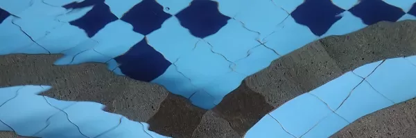 Freshly resurfaced concrete pool interior with smooth blue finish in Florida backyard