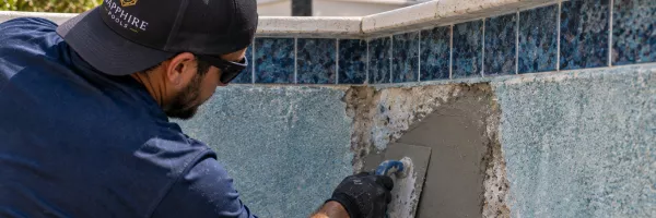 Rough patch of gunite pool interior being repaired below the waterline