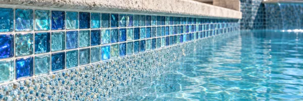 Pebble pool finish with glass mosaic waterline tile in a custom Florida pool
