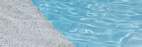 Quartz pool finish sample showing speckled colored crystals under water