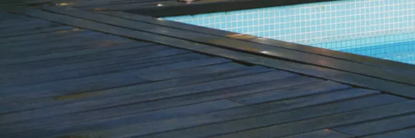 Renovated pool deck with cool slip-resistant pavers around backyard swimming pool
