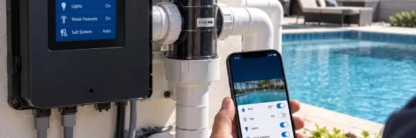 Homeowner adjusting pool automation settings on a phone app poolside