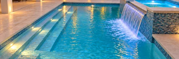 Attached spa with sheer descent water feature spilling into remodeled pool