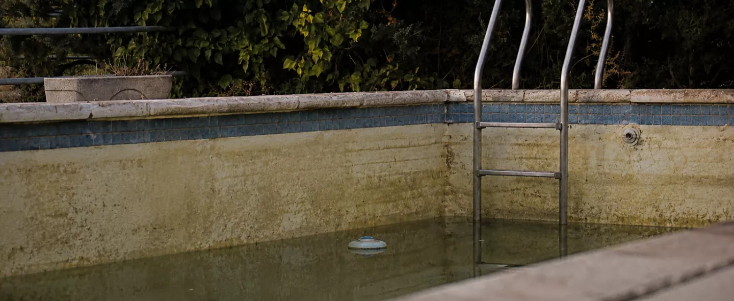 Worn stained pool surface before resurfacing at a West Palm Beach home