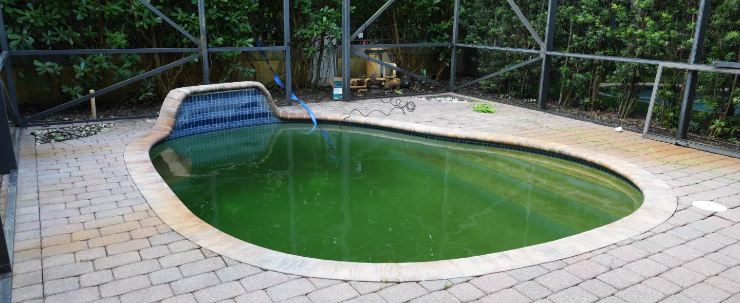 Worn, cracked pool coping before replacement at a South Florida home