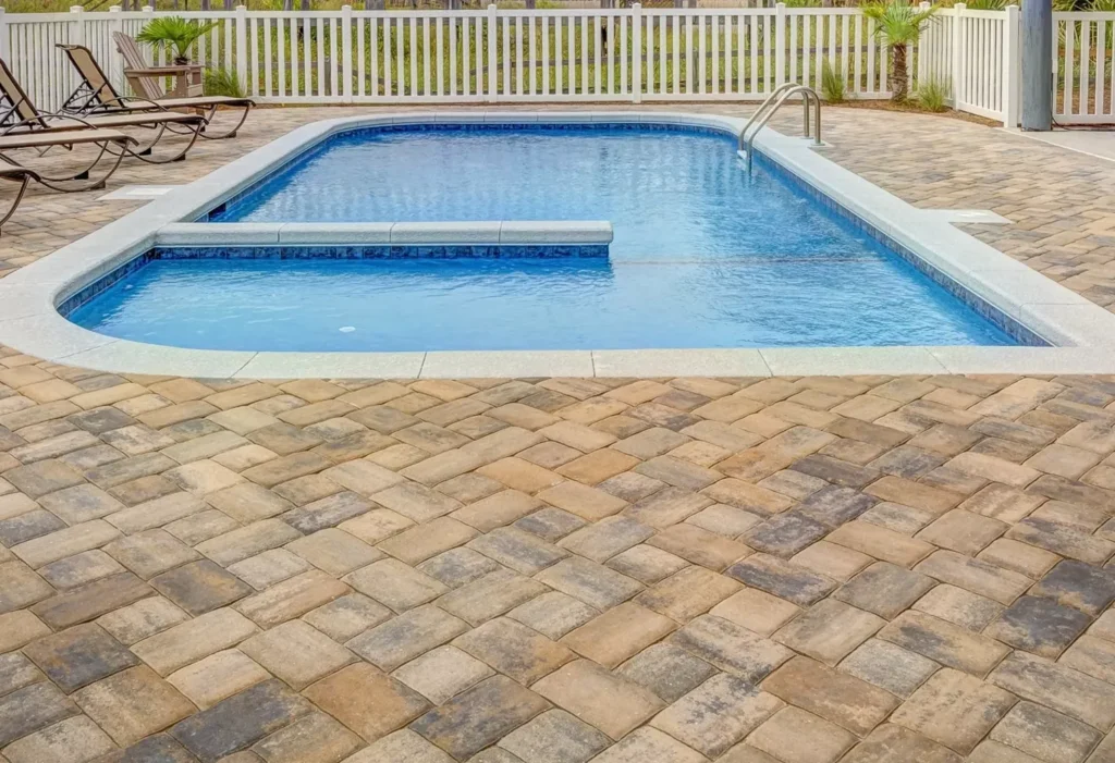 Concrete pool beside a South Florida home with palm trees