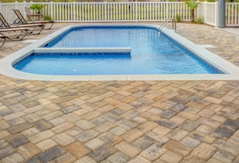 Concrete pool beside a South Florida home with palm trees