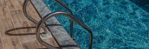 Elegant marble coping installed around a swimming pool with natural stone veining