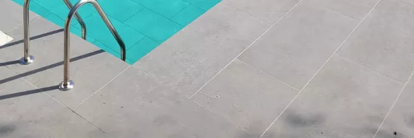 Modern square-edge pool coping with clean straight lines around an inground pool