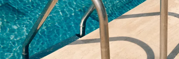 Modern porcelain coping installed along the edge of a residential swimming pool
