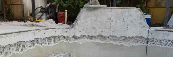 Crew setting new travertine coping stones along an inground pool edge