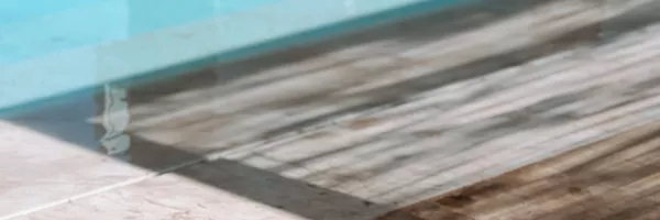 Light travertine coping installed around a residential swimming pool in South Florida